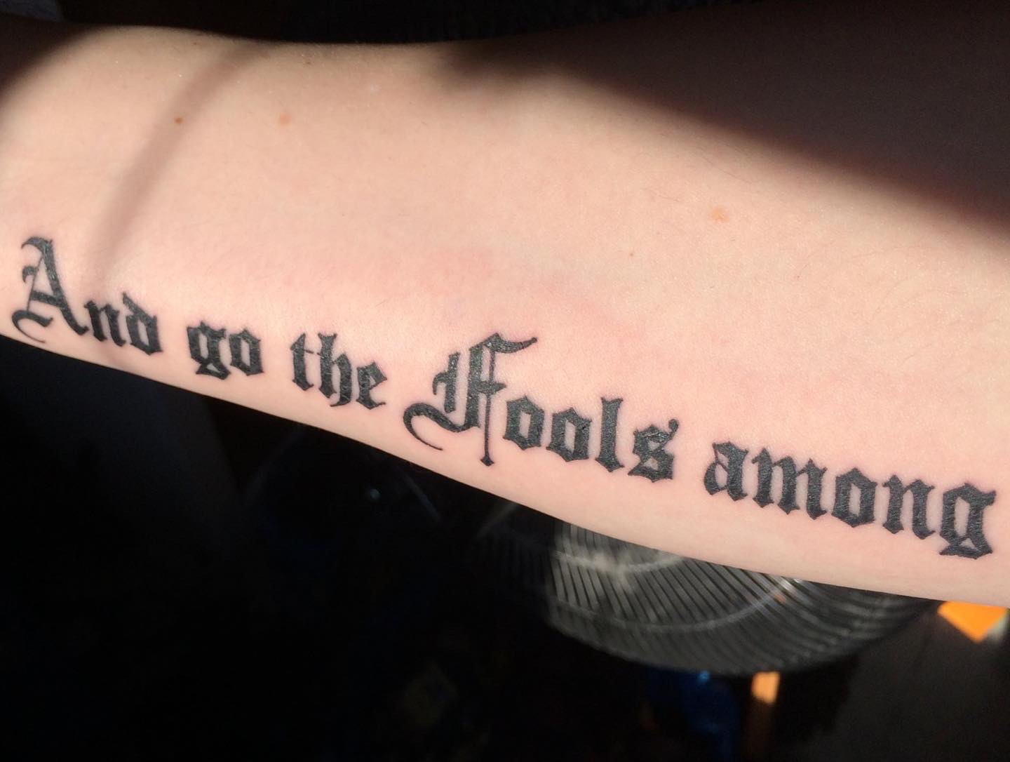 Tristan’s actual arm tattoo, with the lettering And go the Fools among