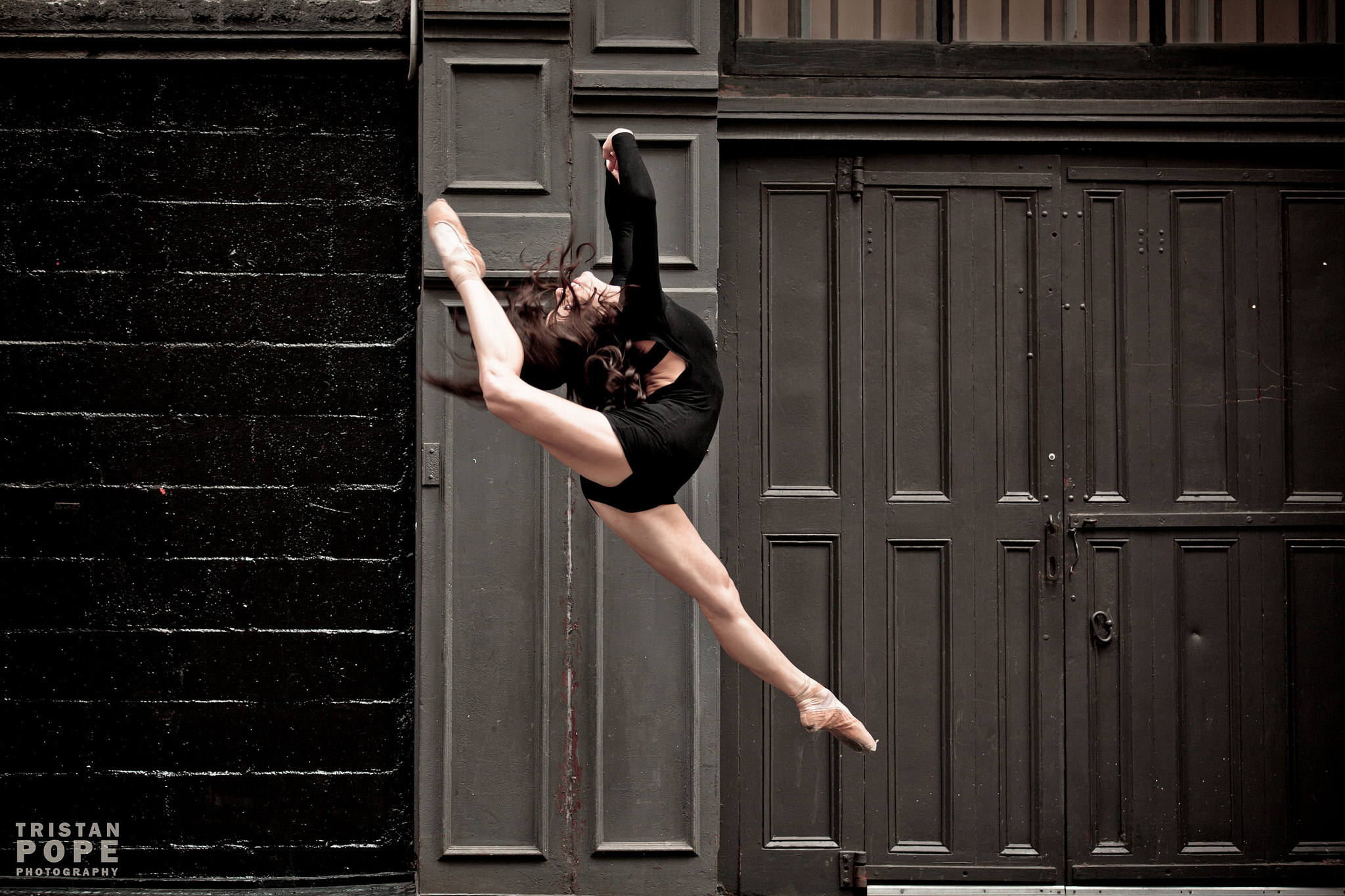 A dancer leaps against a New York doorway, photographed by Tristan Pope