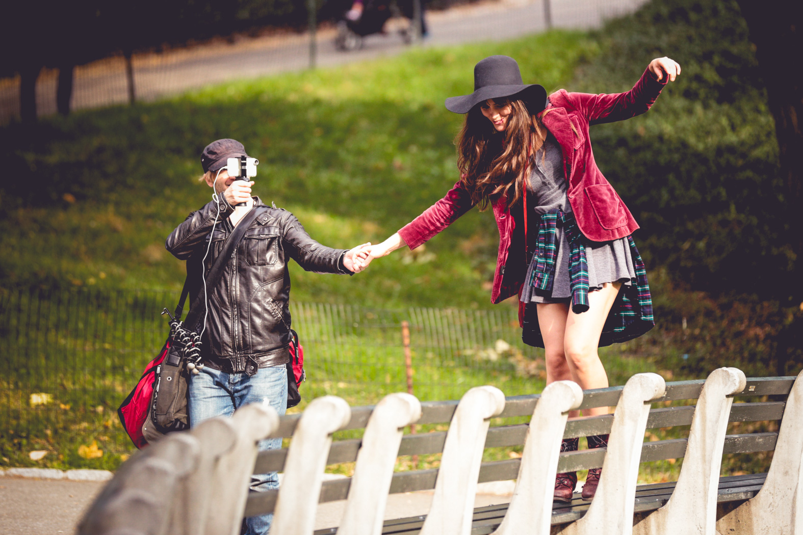 Tristan filming Rachael balancing along a park bench during Romance in NYC