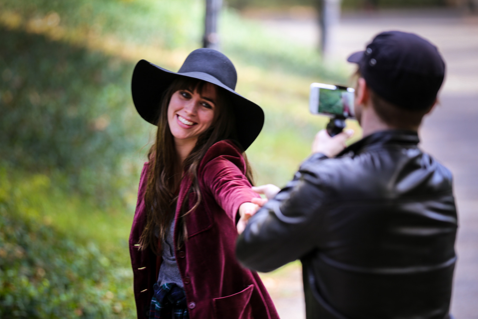 Rachael McOwen reaching toward Tristan Pope’s iPhone on the set of Romance in NYC